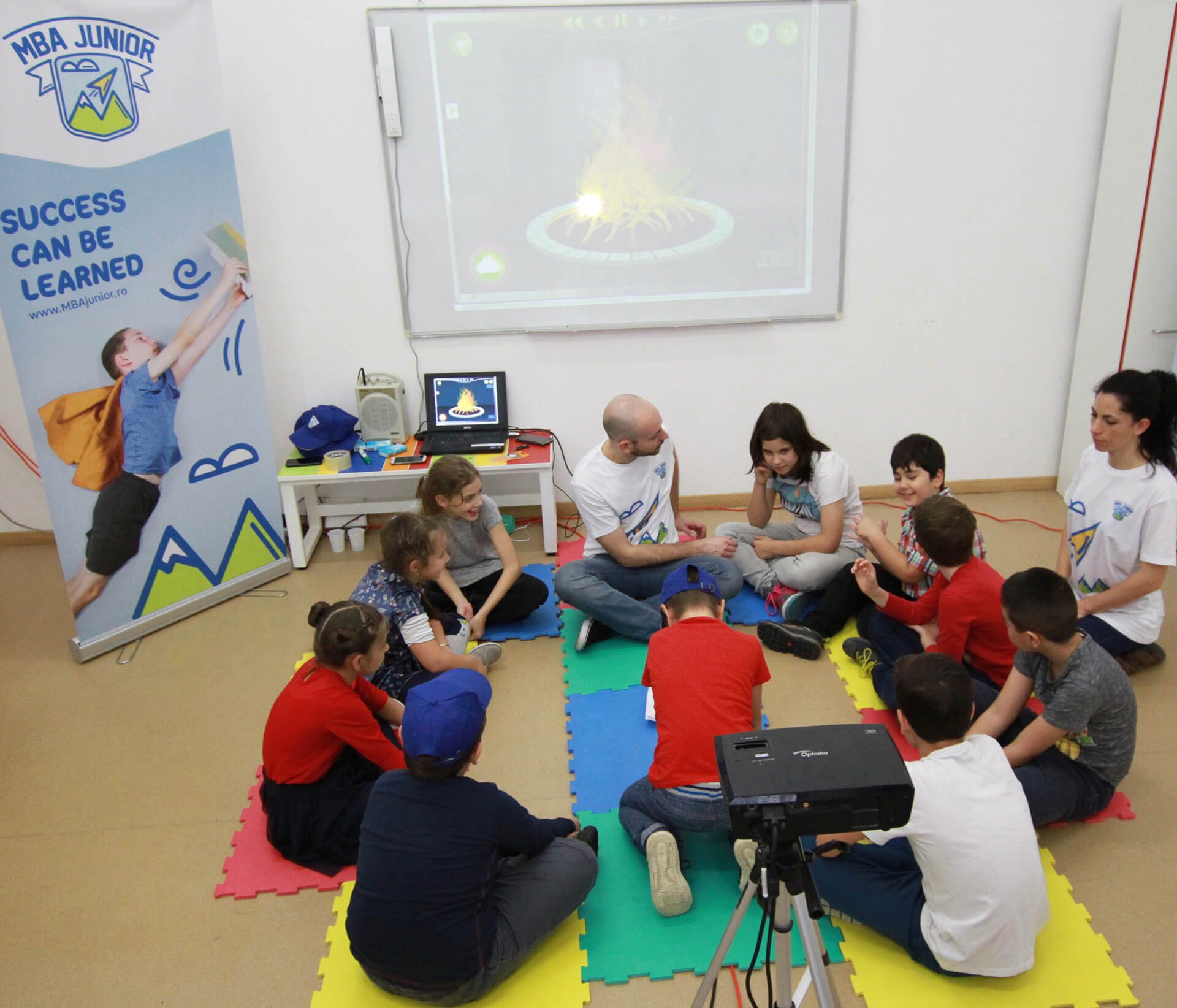 Copii și facilitatori lucrând împreună într-un atelier MBA Junior
